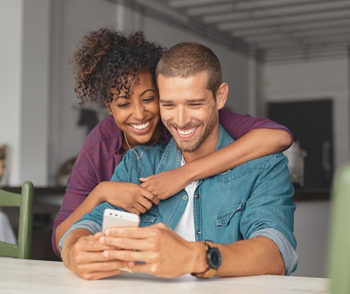 happy couple smiling at phone